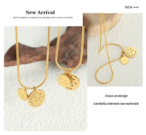 Detail of gold snake chain necklace with Good Luck coin and zircon inlaid pendant