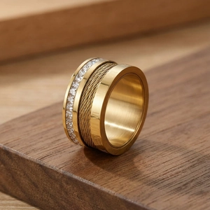 Detailed close-up of wide gold ring with Roman numerals, cable inlay and zircon stones