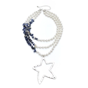 Detail van meerlagige kralenketting met parels, turquoise steen en sterrenhanger