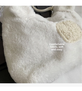 Close-up of fluffy white faux fur texture and round plush patch on this shoulder bag