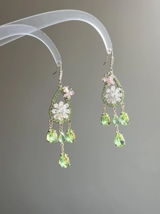 Close-up of gold butterfly flower earrings with green and pink zircon waterdrop pendants