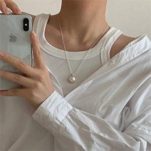 Close-up of minimalist silver pearl necklace worn by a model in a mirror selfie