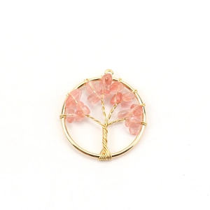 Macro detail of handmade tree of life pendant with copper wire and pink natural stone beads