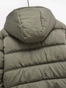 Close-up of olive green quilted hooded puffer jacket showing back detail and horizontal stitching