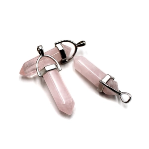Three pink crystal hexagonal point pendants with silver metal bails on a white background