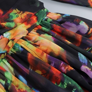 Detail of high waist pleated design and colorful floral print on lightweight fabric
