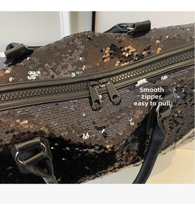 Primer plano de las cremalleras dobles suaves en un bolso de viaje grande con lentejuelas negras