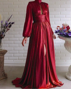 Detail of red metallic pleated evening gown showing the texture and cut-out design