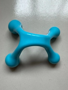 Macro shot of blue four-point manual trigger point massage tool for back and neck relief