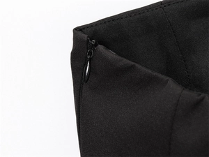 Detailed close-up of invisible zipper and woven texture on a black strapless top