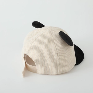 Detail of baby corduroy cap with panda ears and adjustable velcro strap in cream white
