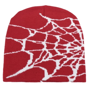 Detailed view of red knitted beanie featuring a white spider web jacquard pattern