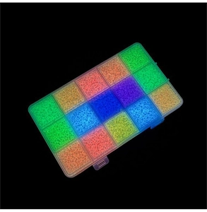 Luminous glass seed beads in multiple colors organized in a transparent plastic storage box