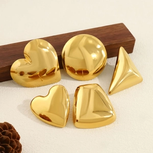 Polished 18K gold geometric heart and round stud earrings set on a clean textured background