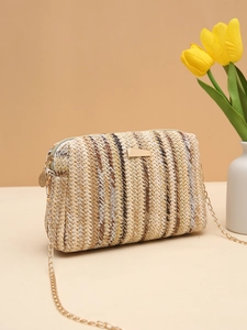 Detail of striped woven straw bag with gold chain strap and decorative metallic plate