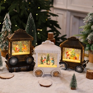Detail of vintage Christmas carriage lanterns with Santa and snowman scenes in artificial snow