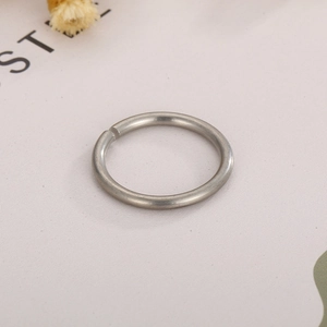 Macro detail of silver stainless steel open ring with subtle brushed metal texture