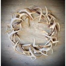 Close-up of textured natural antler wreath on vintage wooden background for rustic decor