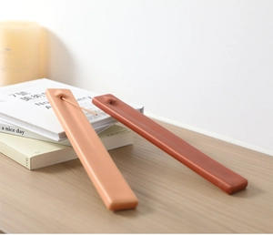 Detalle de portainciensos cerámicos minimalistas en naranja mate y rojo sobre madera