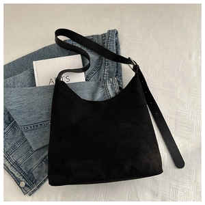 Close-up of matte texture black underarm bag with adjustable leather strap and silver buckle