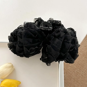 Draufsicht auf eine große schwarze Chiffon-Haarklammer mit Schleife auf weißem Tisch