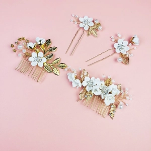 Détail de parure mariée avec fleurs en céramique blanche, strass et perles sur fond rose