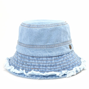 Light blue denim bucket hat with frayed edges and vintage metal badge on white background