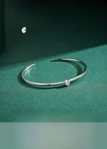 Detailed close-up of a silver open cuff bracelet with a sparkling round zircon stone