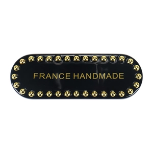 Detail of black acetate hair clip with gold metal beads and France Handmade lettering
