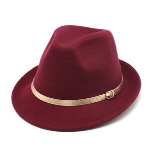 Detail of burgundy wool fedora hat featuring a gold textured band and metal buckle