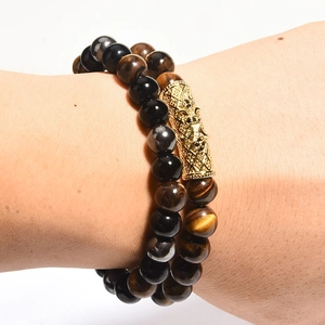 Close-up of double-layer bracelet with obsidian, tiger eye beads and gold dragon charm