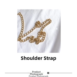 Detail of a polished gold metal chain shoulder strap for luxury acrylic evening clutch bags