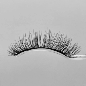 Natural short faux mink eyelashes with clear band on a curved professional display