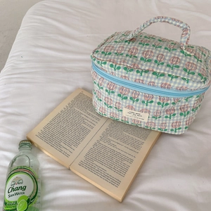 Trousse de maquillage en coton matelassé à fleurs et carreaux bleus dans un décor chic