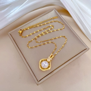 Macro view of gold pipa necklace with pearl inlay on soft silk background