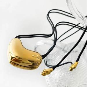 Elegant 14K gold-plated irregular bean pendant on a minimalist black leather cord necklace