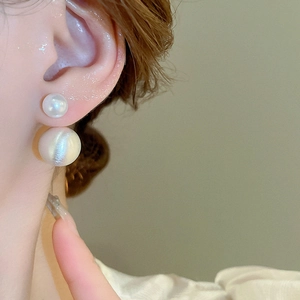 Side view of model wearing elegant double-beaded white pearl earrings for a minimalist look