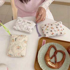 Detailed close-up of quilted floral coin purse showing cotton texture and zipper strap