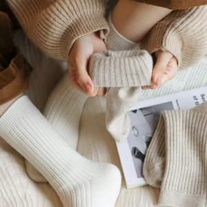 Close-up of thick ribbed knit texture on cream and light brown cotton blend crew socks