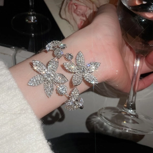 Elegant floral cuff bracelet encrusted with white rhinestones on female wrist