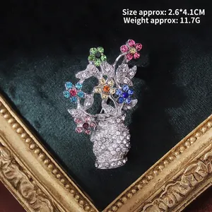 Detailed view of vintage baroque floral vase brooch with colorful rhinestones on velvet