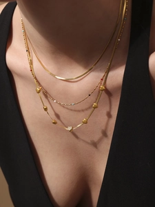 Detailed view of triple-layered 18k gold plated stainless steel necklace with heart pendants