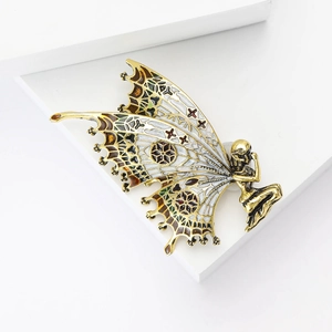 Detailed macro view of an enamel butterfly fairy brooch with intricate vintage metalwork