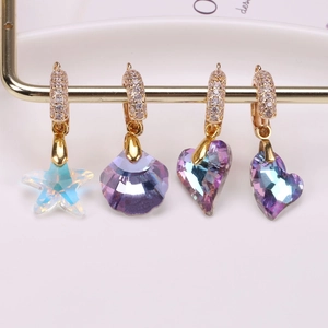 Colorful aurora crystal charms in heart, shell, and star shapes on gold earring hooks