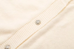 Gros plan détaillé du cardigan en maille avec boutons en métal gravés de style blason