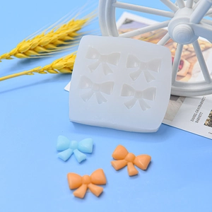 White silicone DIY bow mold with resin bow samples on a bright blue background