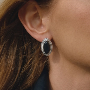 Retro stainless steel stud earrings with black drip oil finish on a model's ear