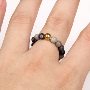 Elegante handgemaakte ring van natuursteen kralen met een centrale 18k gouden kraal