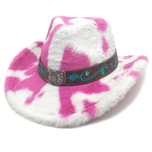 Détail d'un chapeau de cowboy rose à motif vache avec bande en cuir et boucle papillon argent