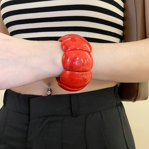 Macro detail of red acrylic marble textured segmented bracelet for women on wrist